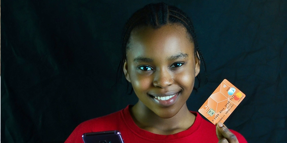 Mulher segunrando um cartão de crédito com limite disponível